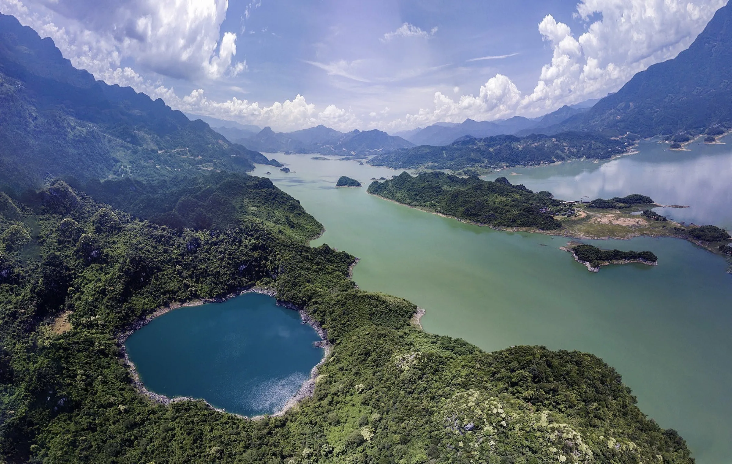 The emerald Dragon Eye Lake ringed by limestone cliffs, Hoa Binh, Vietnam.