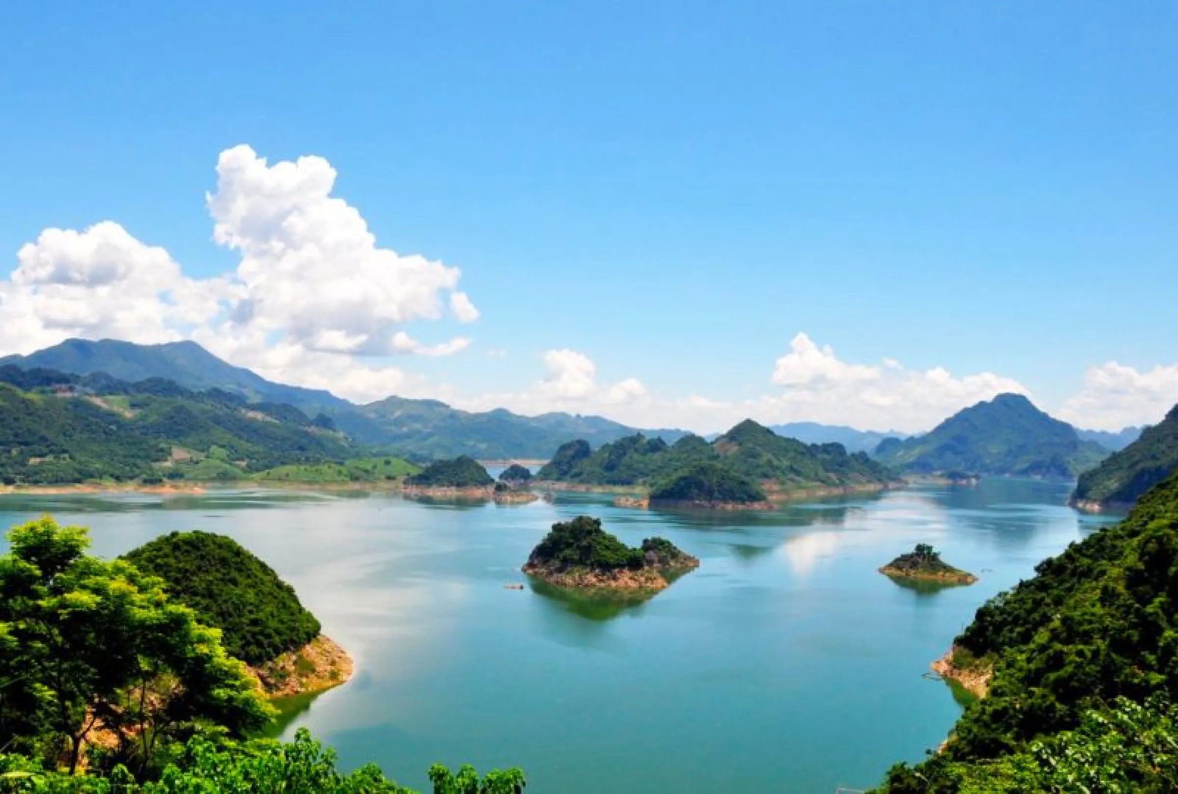 Limestone islands scattered across the turquoise water of Hoa Binh Lake, Vietnam.