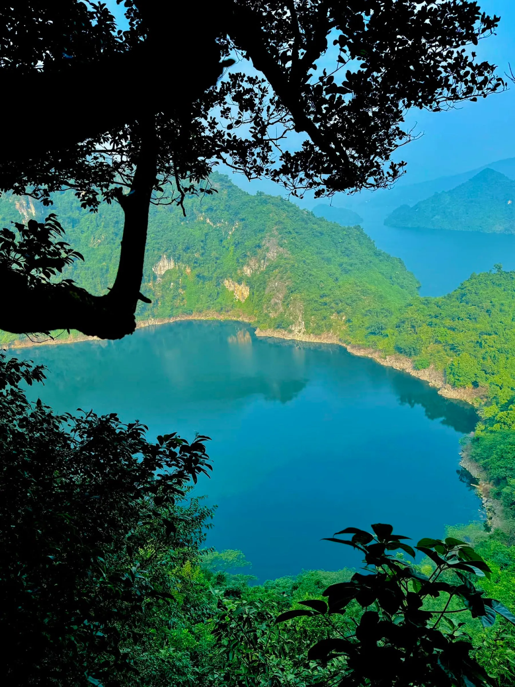 View over the jade Dragon Eye Lake and forested hills, Vietnam.