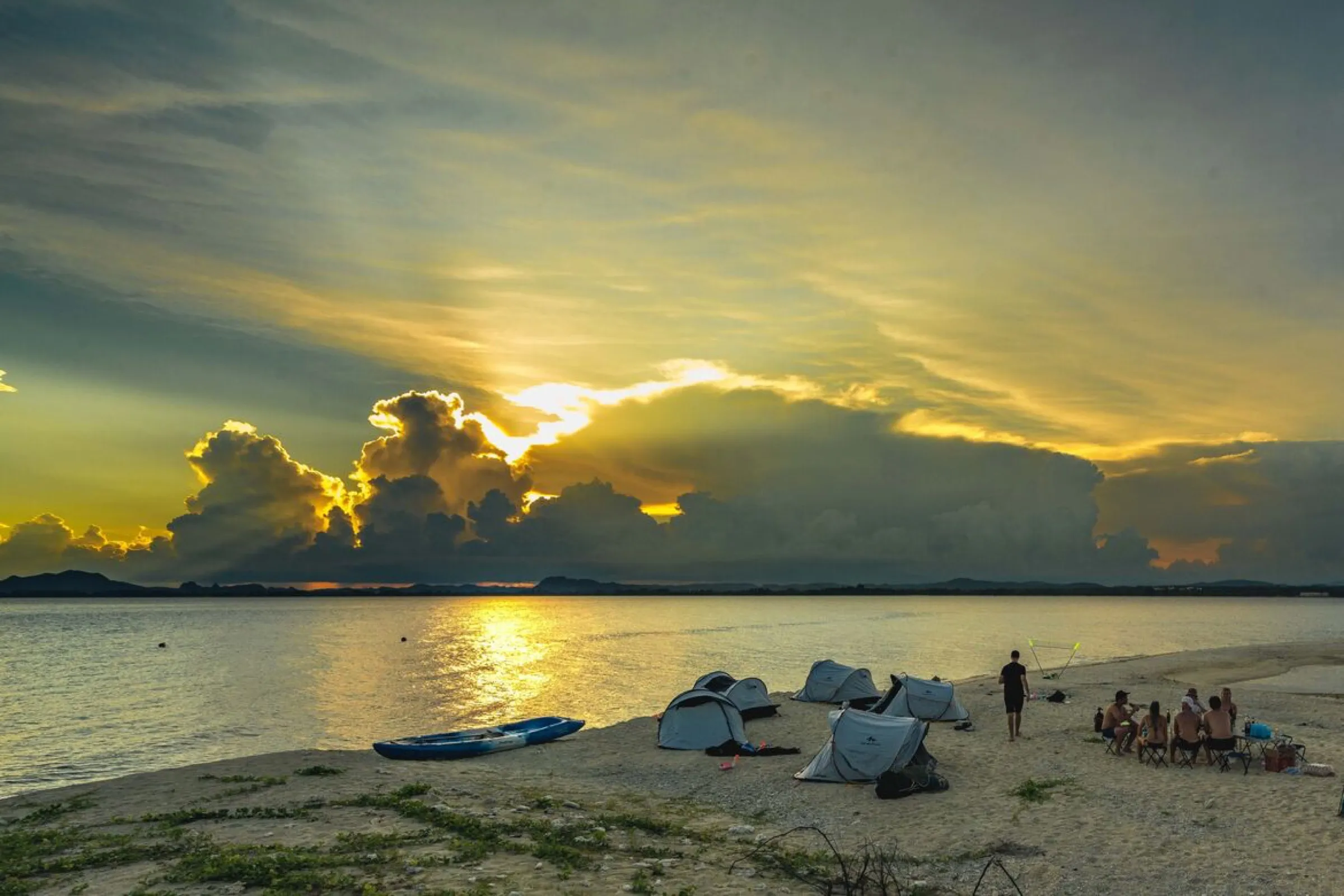 Tents and a campfire on the beach of Koh Kye at sunset, Thailand.
