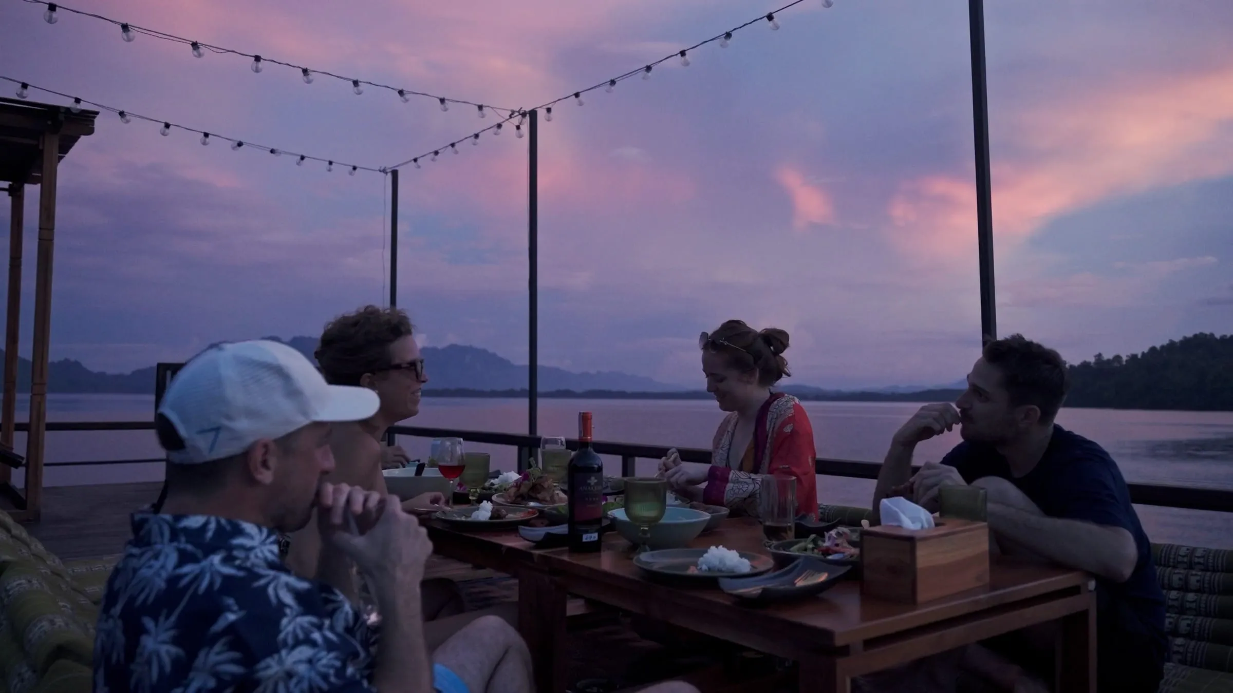 Dinner served on the deck of a floating house at sunset on Khao Laem Lake, Thailand.