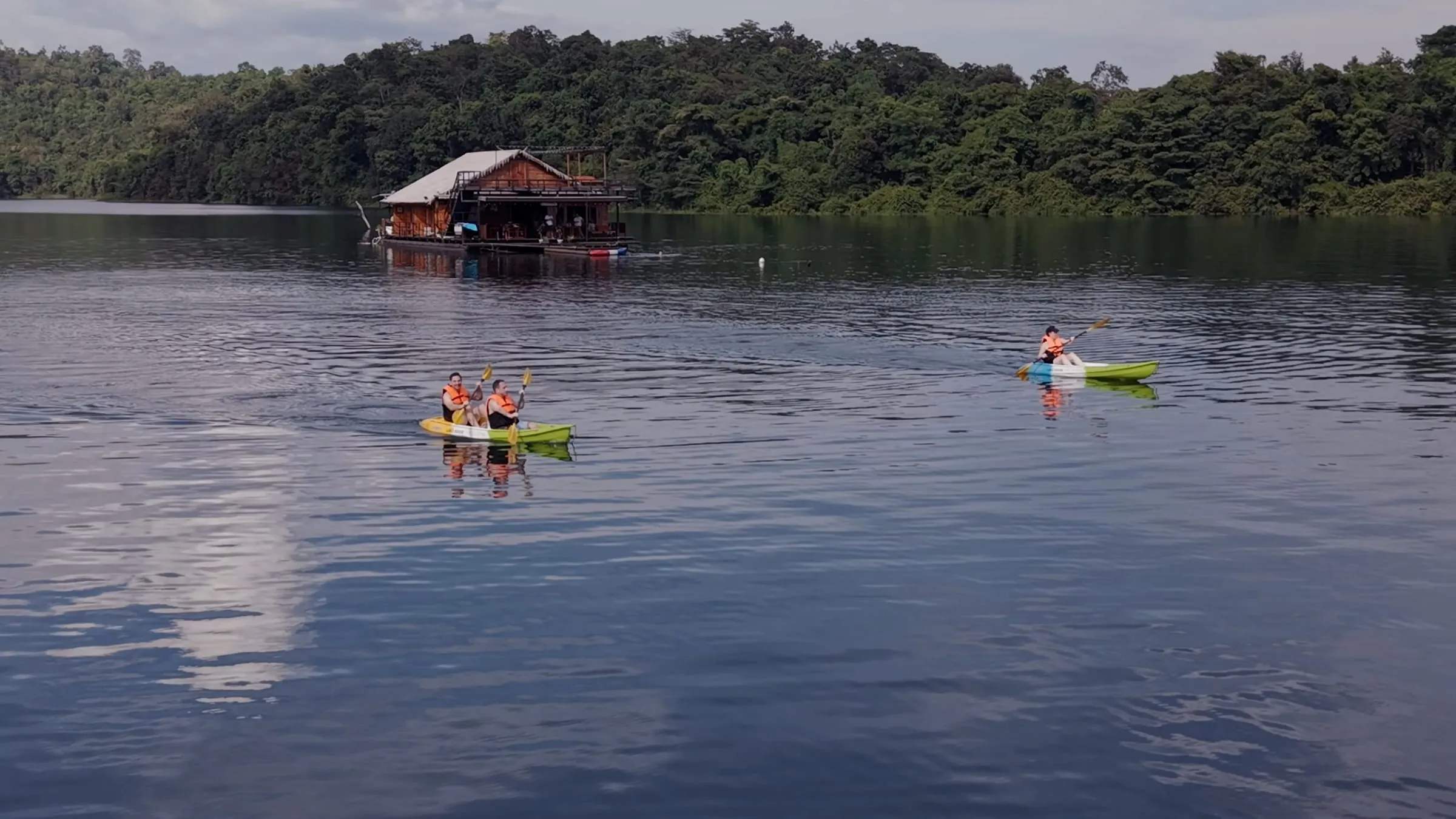 Kayaks tied alongside a floating house on Khao Laem Lake, Thailand.