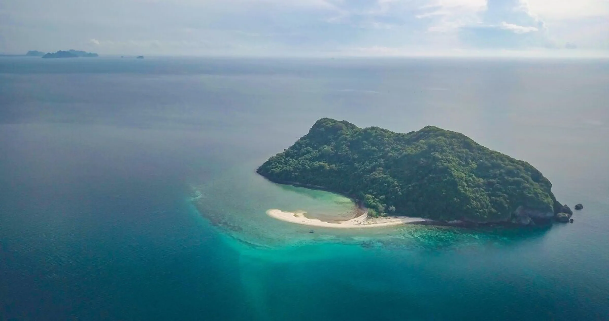 Aerial view of Koh Kye, a jungle island ringed by white coral sand and turquoise sea.